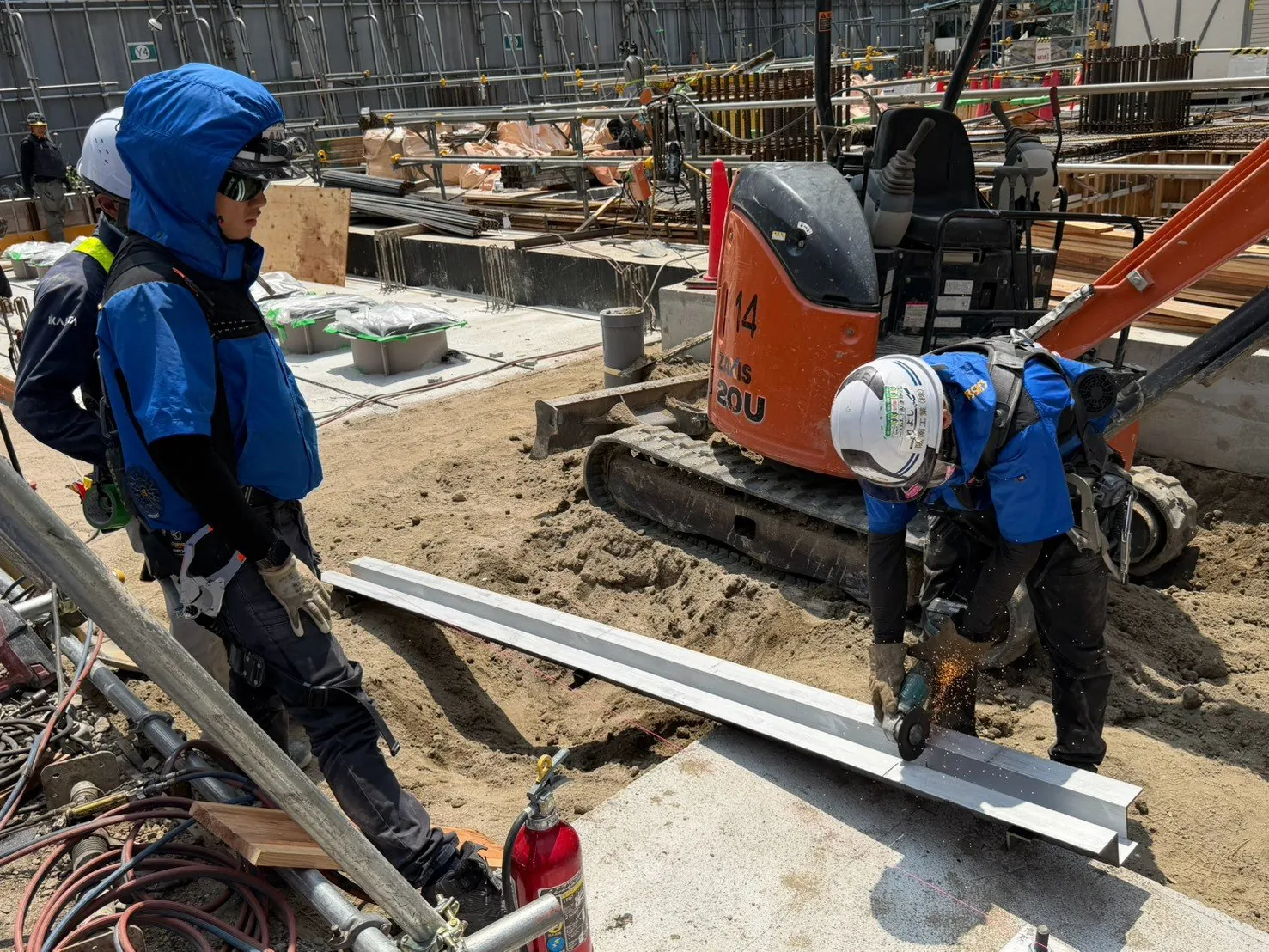 都市部の現場でミニユンボと鋼材を扱う土木作業